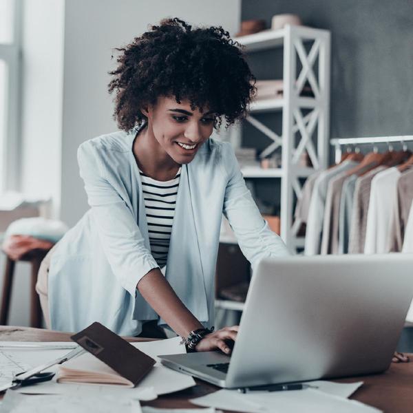 lady wearing vest looking at a laptop