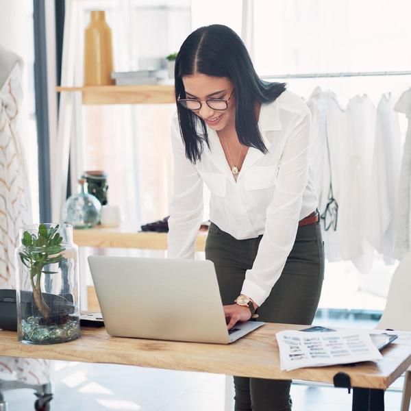 Lady wearing white long sleeve shirt working her laptop