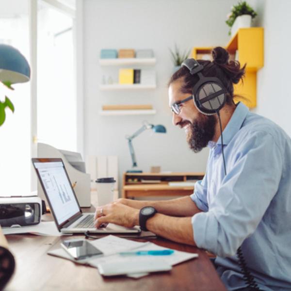 man with headphones typing on his laptop