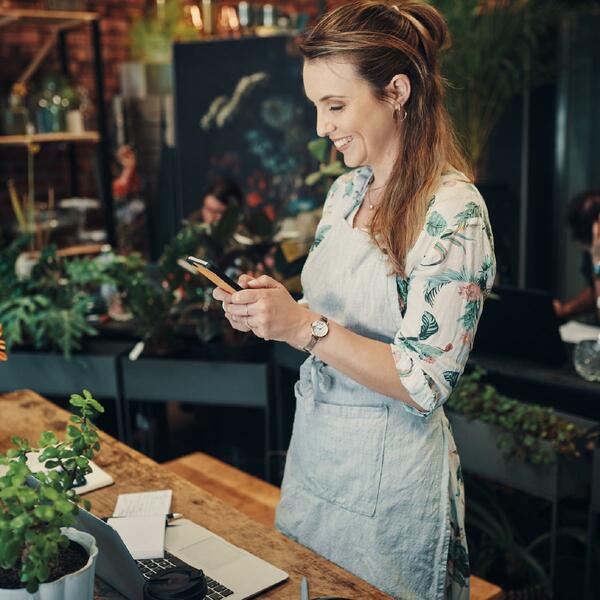 lady wearing apron looking at mobile phone
