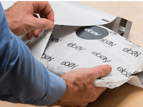 man packing item wrapped in eBay tissue paper