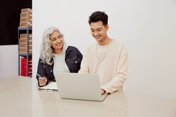 man and woman looking at laptop