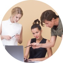 two ladies and a gentleman looking at a content on laptop