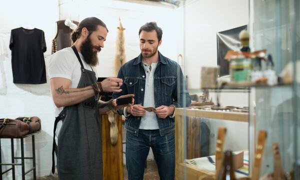two men looking at leather items
