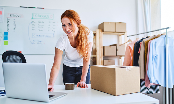 lady leaning over desk using laptop