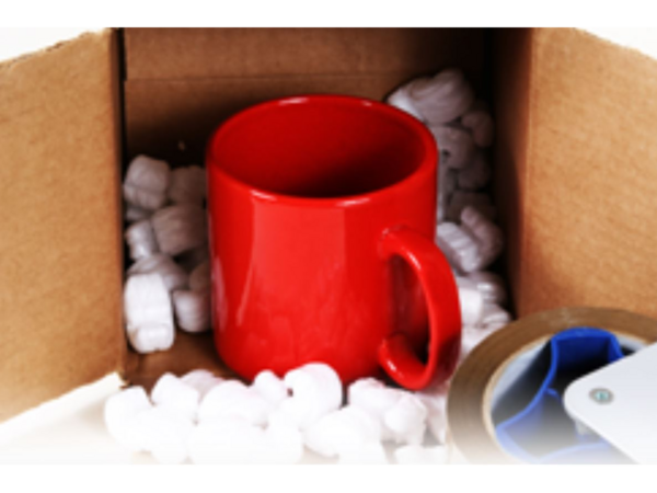A mug inside of an open box with packaging materials around it