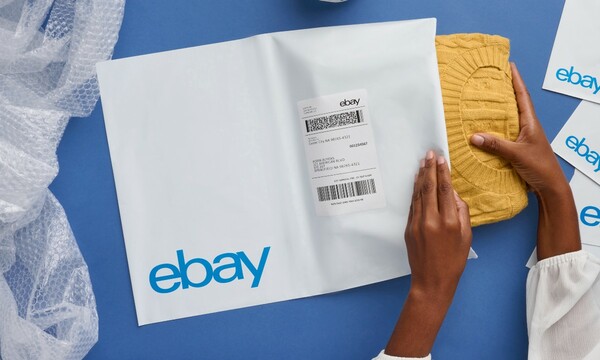 woman packaging yellow sweater in eBay mailer