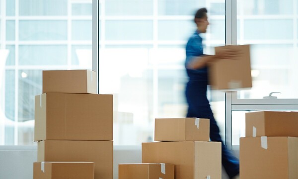 blurry image of man carrying boxes