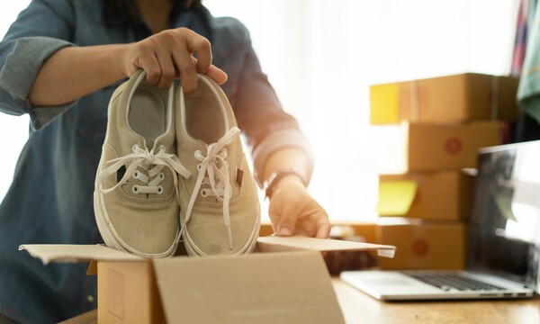 Woman packaging shoes into box