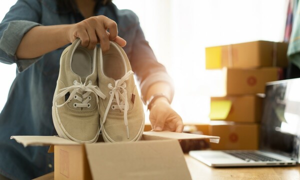 person packaging shoes into box