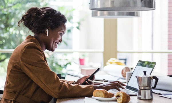 Woman typing on a keyboard, smiling.