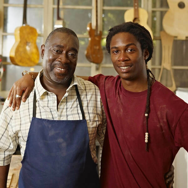 two men with hanging guitars on the background