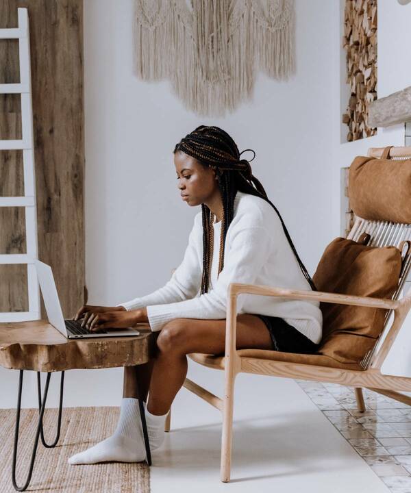 woman sitting while typing on laptop