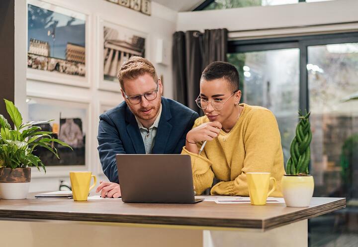 Two people looking at a laptop.