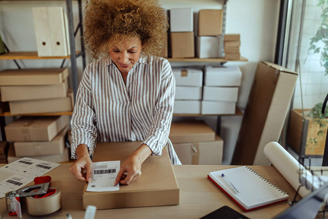 woman putting label on box