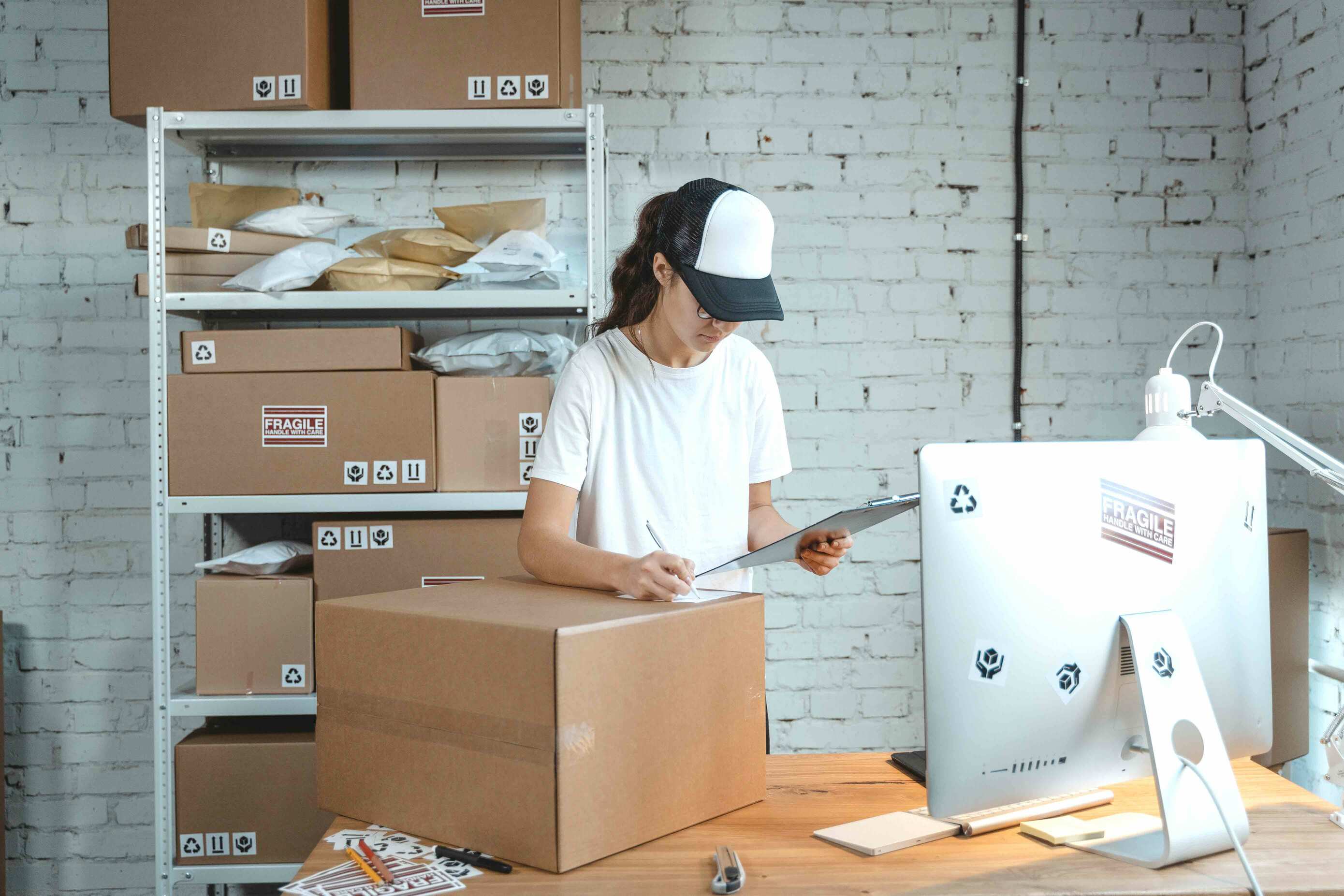 woman writing label on large box