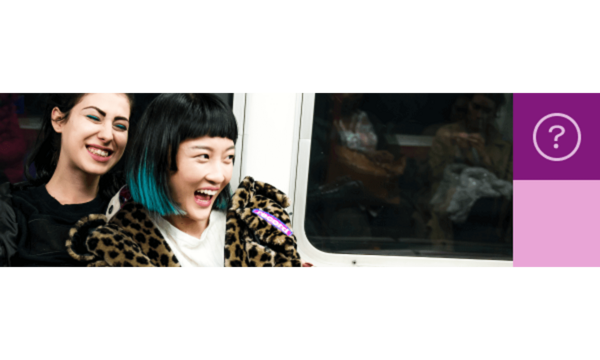 Two women laughing on the subway train.