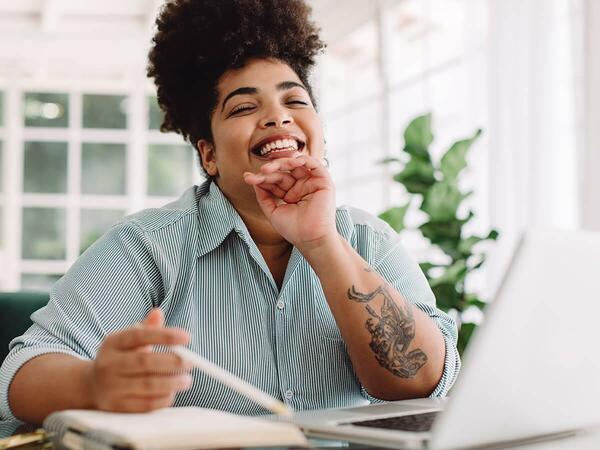 lady smiling with laptop in front of her