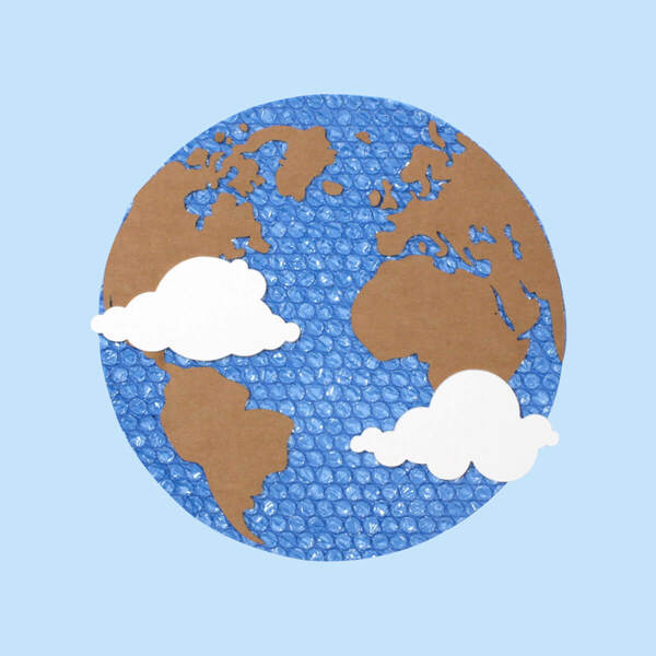 Packaging materials displayed as a globe with blue bubble wrap, ripped cardboard and white paper cut to symbolize water, land and clouds.