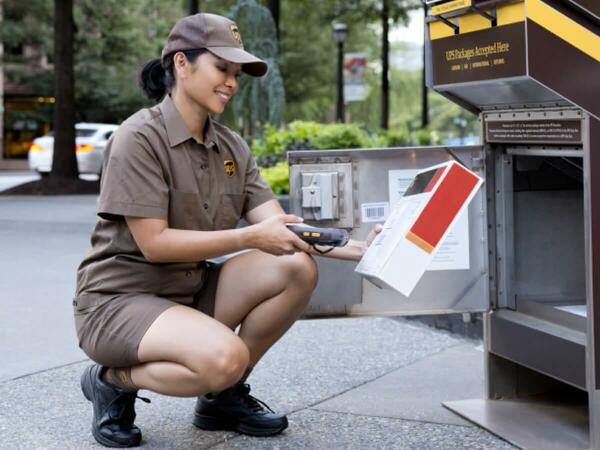 A UPS employee scanning the label on a package she grabbed from the UPS mail dropbox.