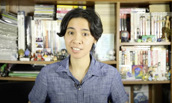 An eBay seller talking about their shipping knowledge while standing in front of a bookshelf.