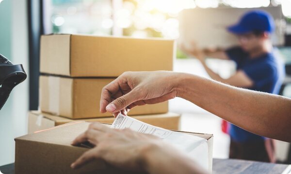 person sticking paper on package