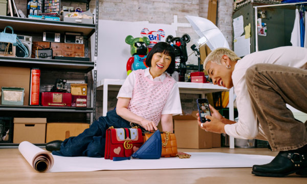 Händlerin und Händler fotografieren Handtaschen.