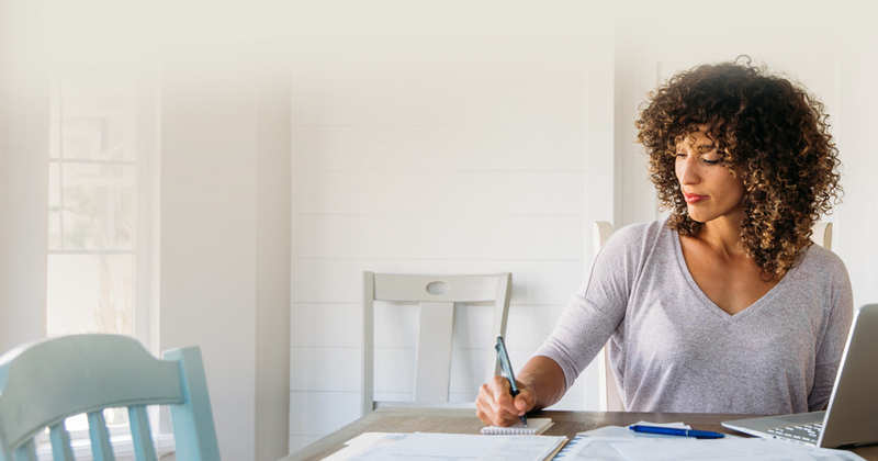 Femme écrivant alors qu'elle était assise au bureau