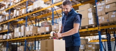 Man taping up box in warehouse