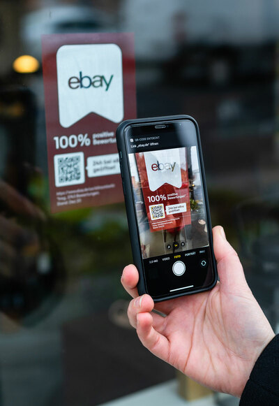 Man holding phone against shop label
