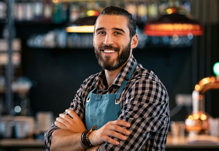 Bar worker standing beside bar