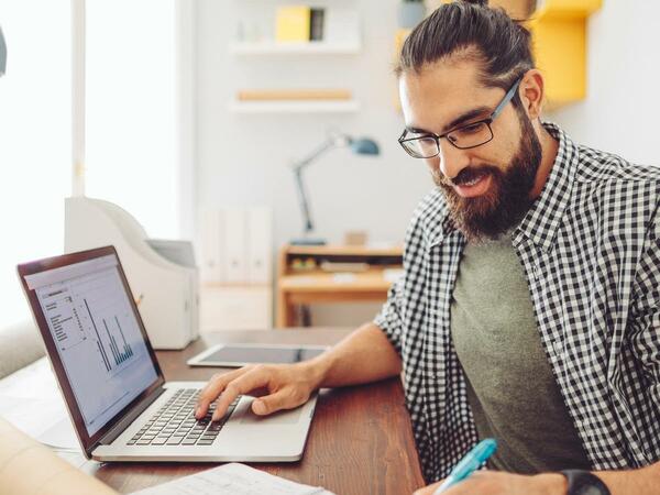 Mann am Schreibtisch am Laptop arbeitend