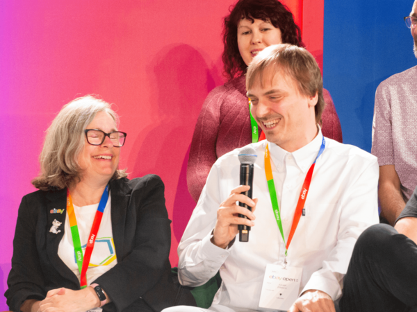 A man and woman laughing together at an eBay panel.