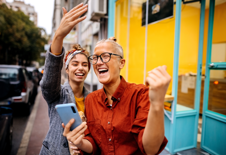 Two women celebrating after receiving good news