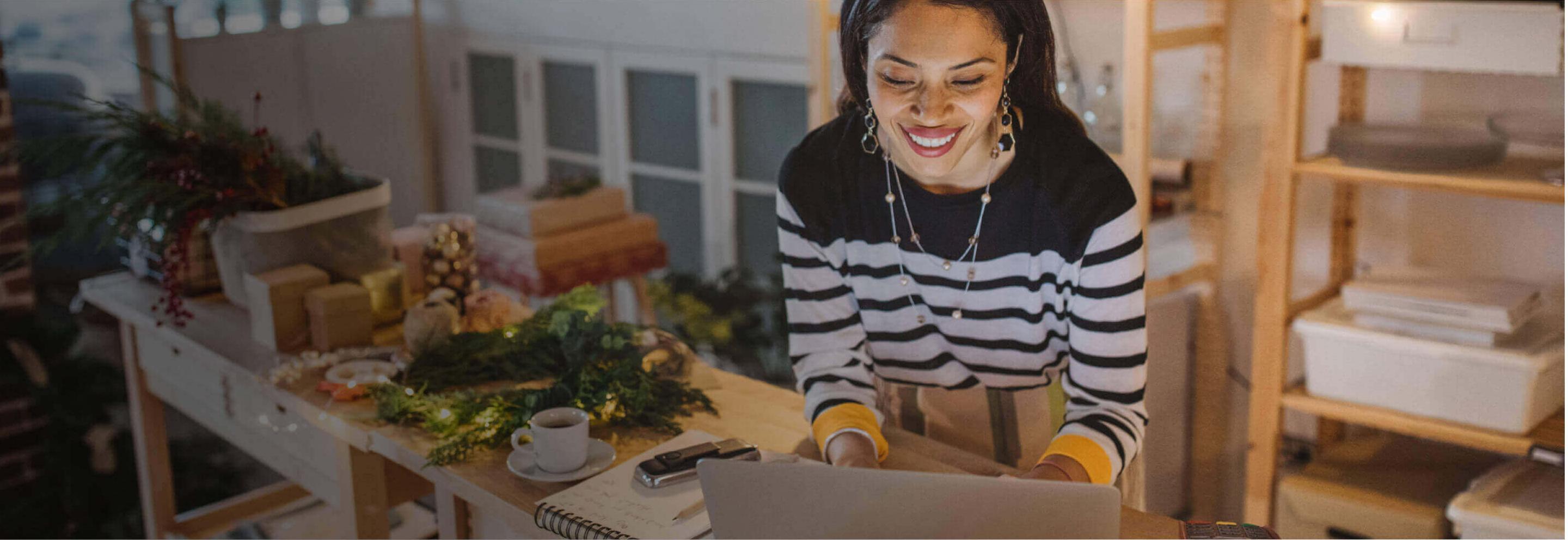lady looking at laptop with holiday decors at the background