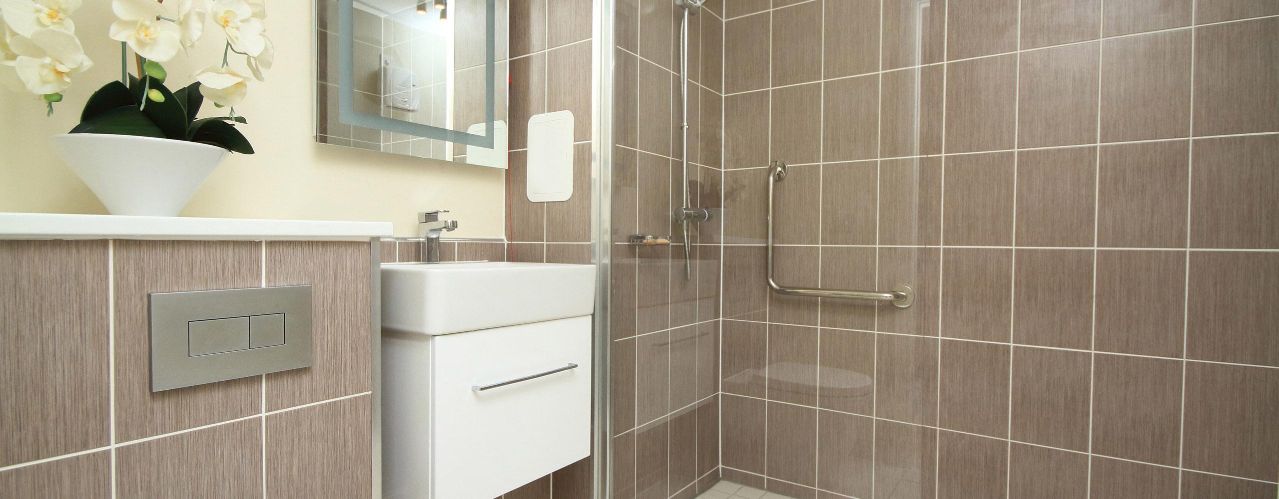 Ein modernes Badezimmer mit einer großen Dusche mit einer Glasfront