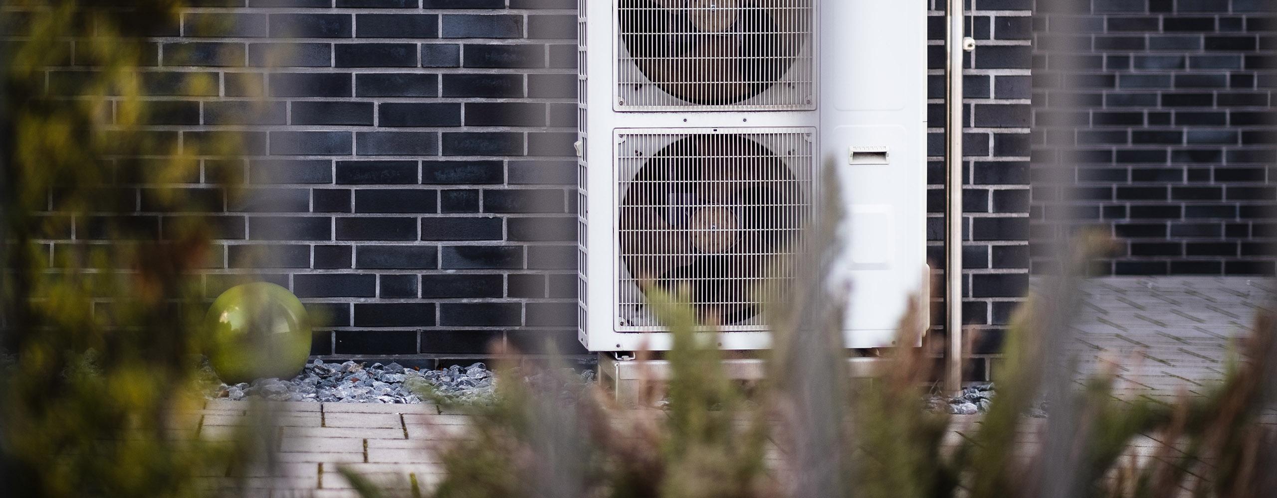 Eine Wärmepumpe an der Außenwand eines Hauses